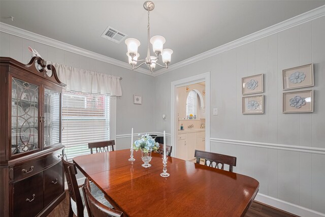 7833 Narcissus St, Houston, TX 77012 - dining area with a chandelier, ornamental molding, and dark wood-style flooring