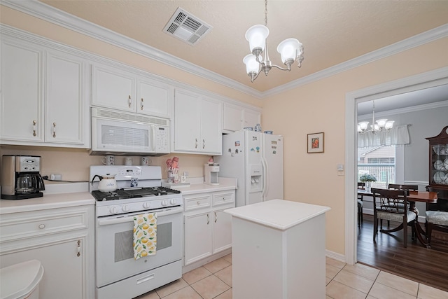7833 Narcissus St, Houston, TX 77012 - kitchen with white appliances, a chandelier, white cabinets, crown molding, and light tile patterned floors