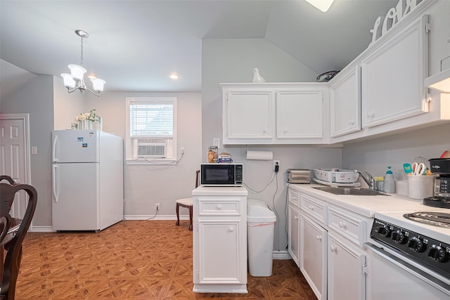 7833 Narcissus St, Houston, TX 77012 - kitchen featuring white appliances, lofted ceiling, white cabinetry, light countertops, and a chandelier