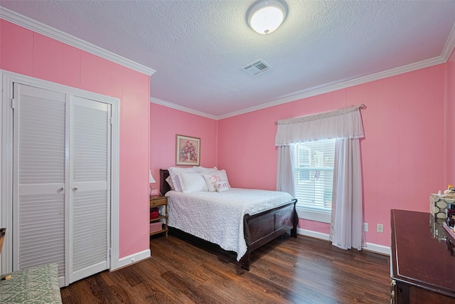 7833 Narcissus St, Houston, TX 77012 - bedroom featuring ornamental molding, dark wood-style flooring, a textured ceiling, and a closet