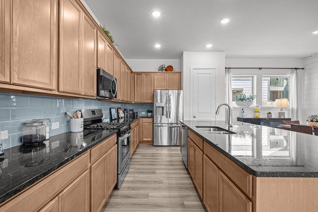 10502 William Park Dr, Missouri City, TX 77459 - kitchen featuring appliances with stainless steel finishes, an island with sink, tasteful backsplash, dark stone countertops, and recessed lighting