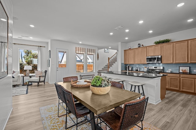 10502 William Park Dr, Missouri City, TX 77459 - dining area featuring stairs, healthy amount of natural light, light wood finished floors, and recessed lighting