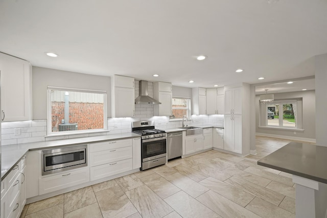 5135 Loch Lomond Dr, Houston, TX 77096 - kitchen featuring appliances with stainless steel finishes, wall chimney exhaust hood, healthy amount of natural light, backsplash, and recessed lighting