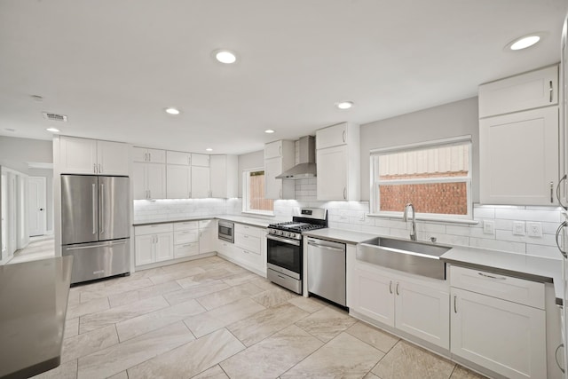 5135 Loch Lomond Dr, Houston, TX 77096 - kitchen with stainless steel appliances, wall chimney range hood, plenty of natural light, tasteful backsplash, and recessed lighting
