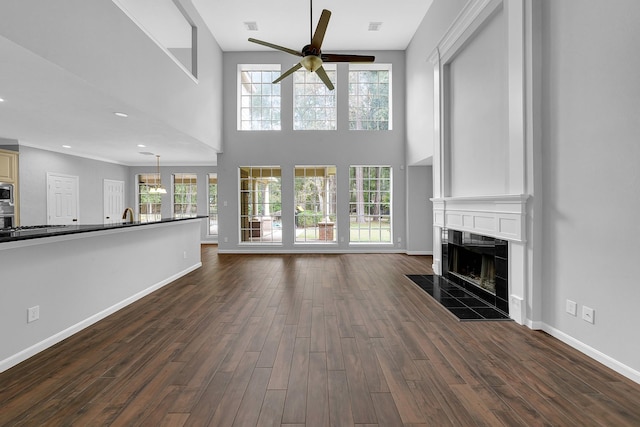 13810 Lakewood Crossing Blvd, Houston, TX 77070 - unfurnished living room with ceiling fan, a high end fireplace, dark wood finished floors, and a high ceiling