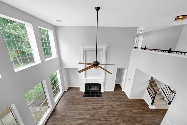 13810 Lakewood Crossing Blvd, Houston, TX 77070 - unfurnished living room featuring a ceiling fan, wood finished floors, a high ceiling, and a fireplace with flush hearth