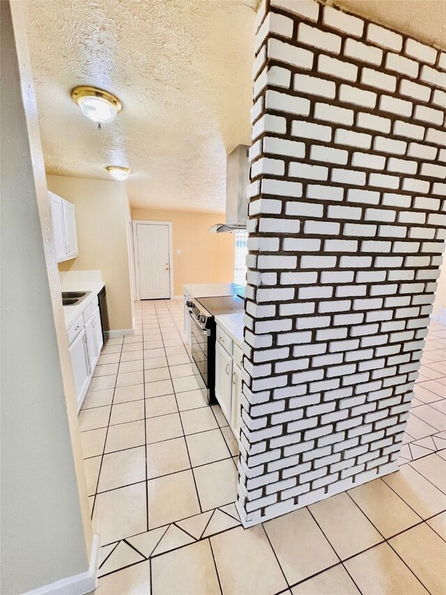 14634 Edenglen Dr, Houston, TX 77049 - kitchen featuring electric range, light tile patterned floors, light countertops, white cabinetry, and island exhaust hood