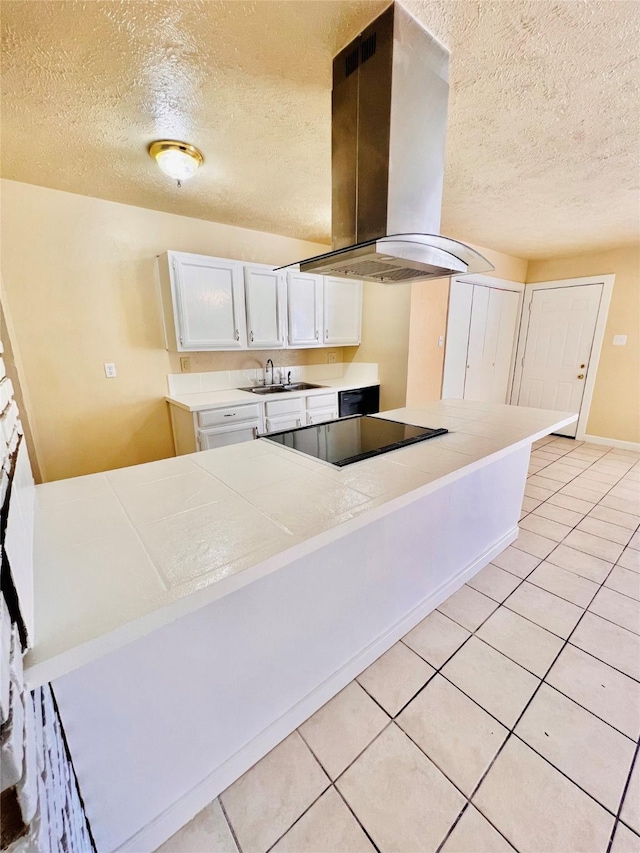 14634 Edenglen Dr, Houston, TX 77049 - kitchen with island exhaust hood, black electric cooktop, a textured ceiling, light tile patterned floors, and tile counters