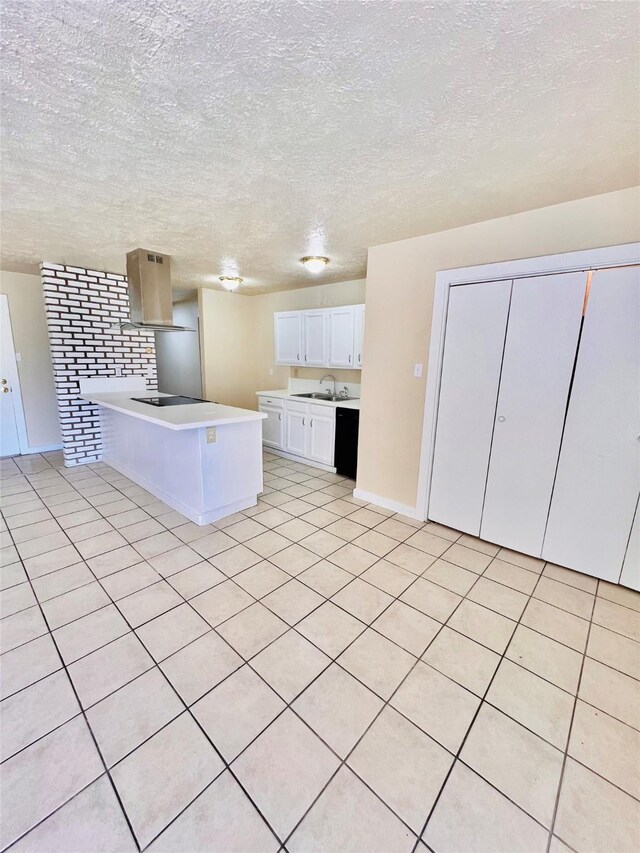 14634 Edenglen Dr, Houston, TX 77049 - kitchen featuring island exhaust hood, a peninsula, light countertops, a textured ceiling, and white cabinetry