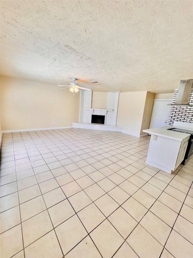 14634 Edenglen Dr, Houston, TX 77049 - unfurnished living room featuring ceiling fan, a fireplace with raised hearth, a textured ceiling, and light tile patterned floors
