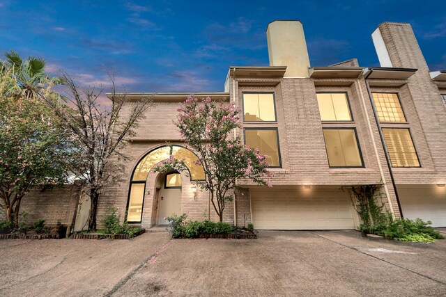 1425 Nantucket Dr Unit G, Houston, TX 77057 - view of front of home featuring driveway, brick siding, a garage, and a chimney