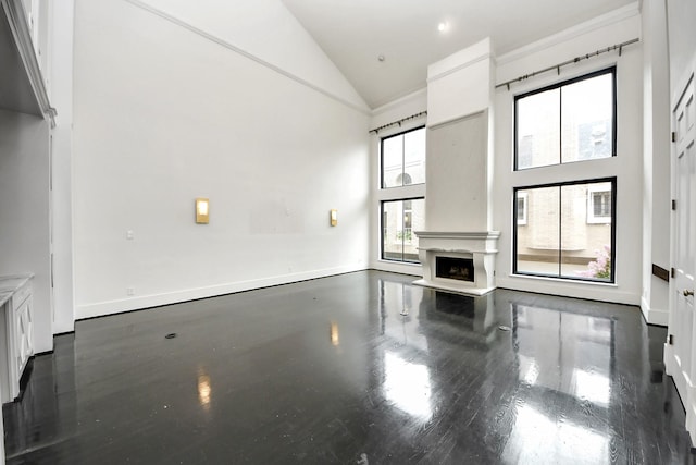 1425 Nantucket Dr Unit G, Houston, TX 77057 - unfurnished living room featuring high vaulted ceiling, a fireplace with raised hearth, and wood finished floors