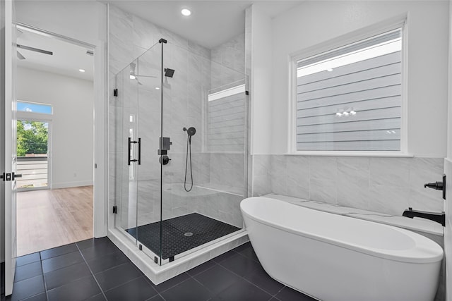 4517 Teton St, Houston, TX 77051 - bathroom featuring a freestanding tub, tile patterned floors, a shower stall, recessed lighting, and tile walls