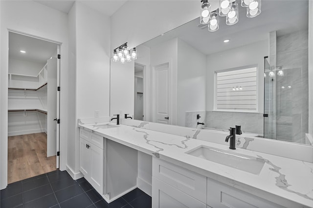 4517 Teton St, Houston, TX 77051 - bathroom with a spacious closet, double vanity, a shower stall, tile patterned flooring, and a chandelier