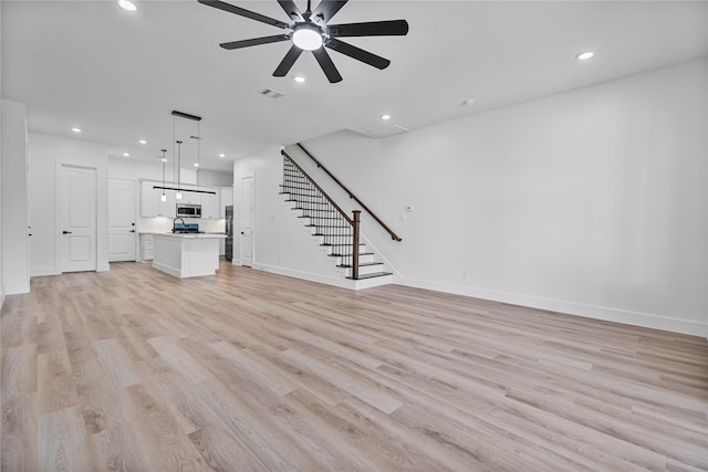 4517 Teton St, Houston, TX 77051 - unfurnished living room with stairs, ceiling fan, light wood-type flooring, and recessed lighting