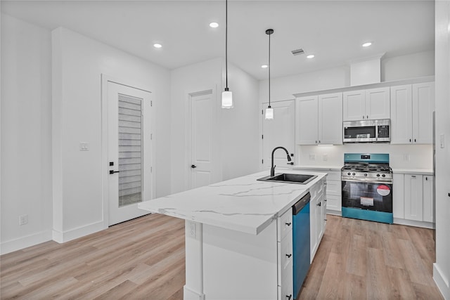 4517 Teton St, Houston, TX 77051 - kitchen featuring stainless steel appliances, light wood finished floors, white cabinetry, an island with sink, and recessed lighting