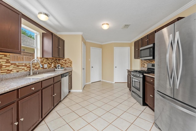 15026 Sunset Creek Dr, Humble, TX 77396 - kitchen with appliances with stainless steel finishes, decorative backsplash, ornamental molding, dark brown cabinetry, and light tile patterned floors