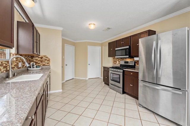 15026 Sunset Creek Dr, Humble, TX 77396 - kitchen featuring appliances with stainless steel finishes, tasteful backsplash, dark brown cabinets, crown molding, and light tile patterned flooring