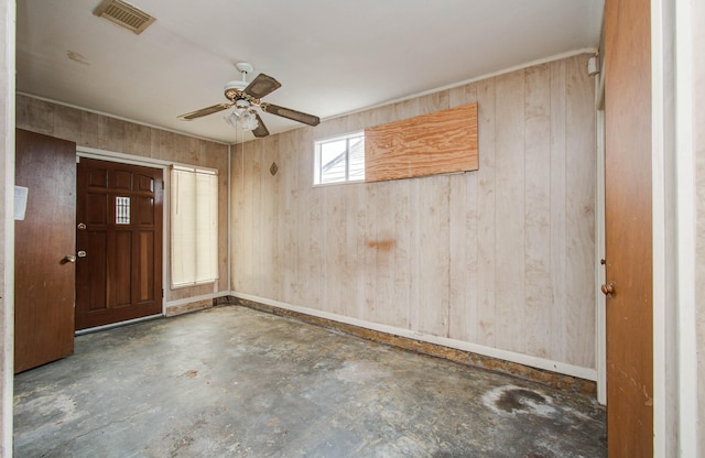 4310 Busiek St, Houston, TX 77022 - entrance foyer featuring concrete flooring, ceiling fan, and wood walls