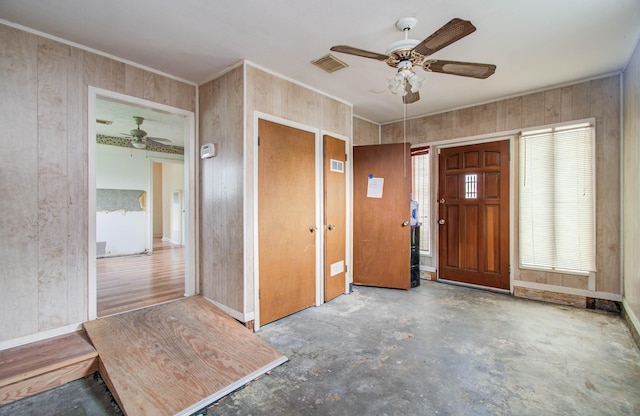 4310 Busiek St, Houston, TX 77022 - foyer with ceiling fan, wood walls, unfinished concrete floors, and crown molding