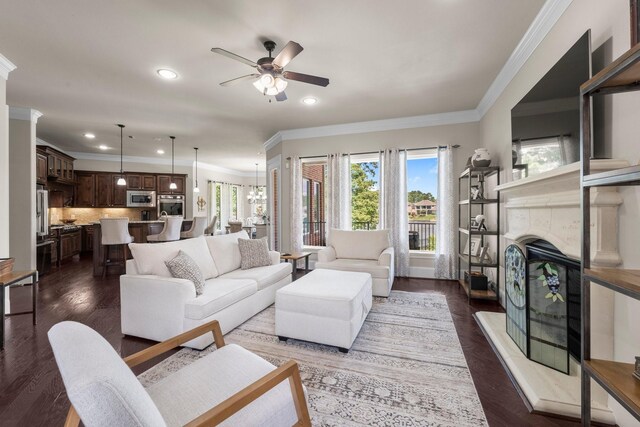 6051 Longmire Trl, Conroe, TX 77304 - living room with ceiling fan, recessed lighting, crown molding, a tile fireplace, and dark wood finished floors