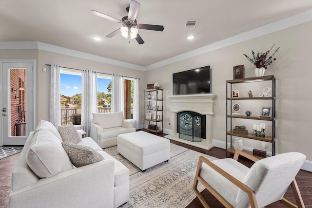 6051 Longmire Trl, Conroe, TX 77304 - living area featuring a ceiling fan, a fireplace with raised hearth, recessed lighting, and ornamental molding