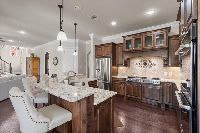 6051 Longmire Trl, Conroe, TX 77304 - kitchen with appliances with stainless steel finishes, open floor plan, decorative backsplash, ornamental molding, and glass insert cabinets