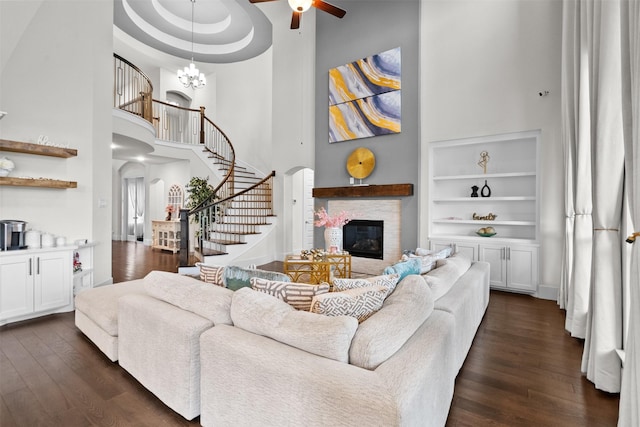 27915 Round Moon Ln, Katy, TX 77494 - living room featuring a high ceiling, a stone fireplace, ceiling fan, stairs, and dark wood finished floors