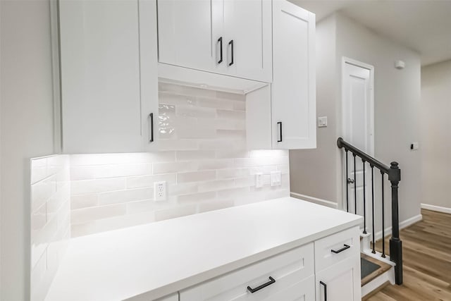 2353 Hoskins Dr, Houston, TX 77080 - kitchen featuring tasteful backsplash, white cabinetry, light countertops, and light wood finished floors