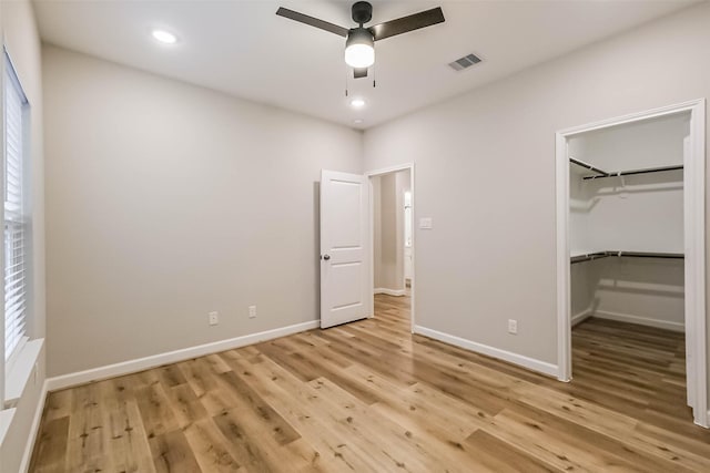2353 Hoskins Dr, Houston, TX 77080 - unfurnished bedroom with light wood finished floors, a spacious closet, recessed lighting, a closet, and multiple windows