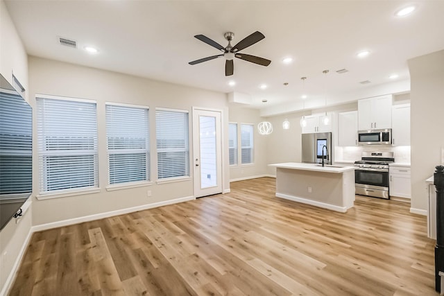 2353 Hoskins Dr, Houston, TX 77080 - kitchen featuring appliances with stainless steel finishes, ceiling fan, open floor plan, light wood-style floors, and light countertops
