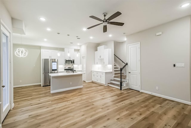 2353 Hoskins Dr, Houston, TX 77080 - kitchen with appliances with stainless steel finishes, light wood finished floors, white cabinetry, and recessed lighting
