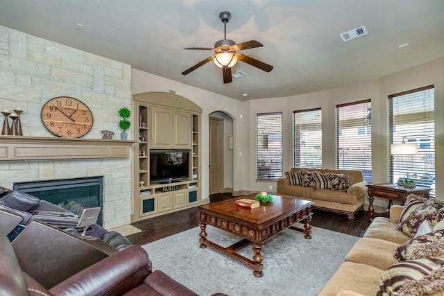 407 Pickney Ave, Sugar Land, TX 77479 - living area with a ceiling fan, dark wood-style flooring, arched walkways, and a stone fireplace