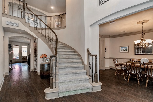 407 Pickney Ave, Sugar Land, TX 77479 - stairs with arched walkways, wood finished floors, a chandelier, a towering ceiling, and crown molding