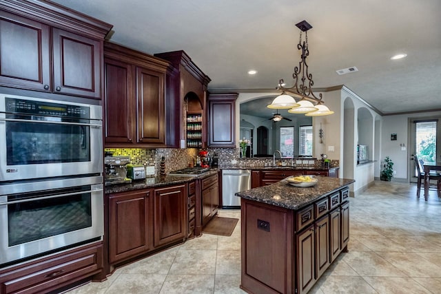 407 Pickney Ave, Sugar Land, TX 77479 - kitchen with appliances with stainless steel finishes, arched walkways, crown molding, backsplash, and a center island