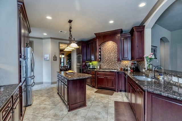 407 Pickney Ave, Sugar Land, TX 77479 - kitchen featuring arched walkways, stainless steel appliances, decorative backsplash, recessed lighting, and a center island