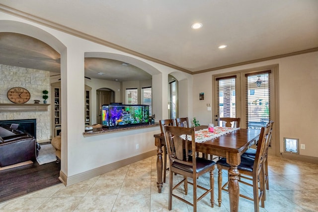 407 Pickney Ave, Sugar Land, TX 77479 - dining space with crown molding, healthy amount of natural light, a stone fireplace, light tile patterned floors, and recessed lighting