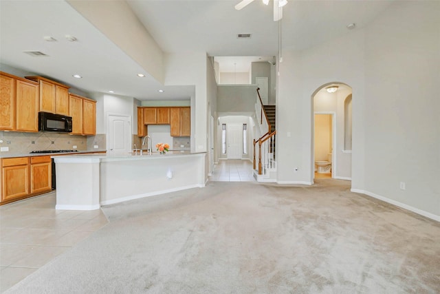 20311 Towering Cypress Dr, Cypress, TX 77433 - kitchen featuring black microwave, arched walkways, light tile patterned floors, gas cooktop, and recessed lighting
