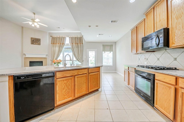 20311 Towering Cypress Dr, Cypress, TX 77433 - kitchen with black appliances, tasteful backsplash, light tile patterned floors, ceiling fan, and a glass covered fireplace