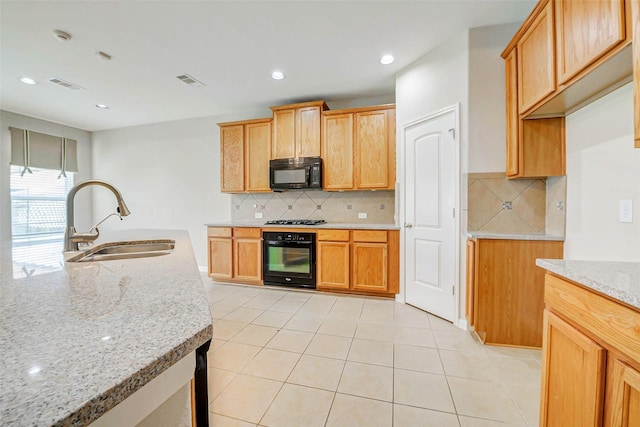 20311 Towering Cypress Dr, Cypress, TX 77433 - kitchen with black appliances, light stone counters, tasteful backsplash, light tile patterned floors, and recessed lighting