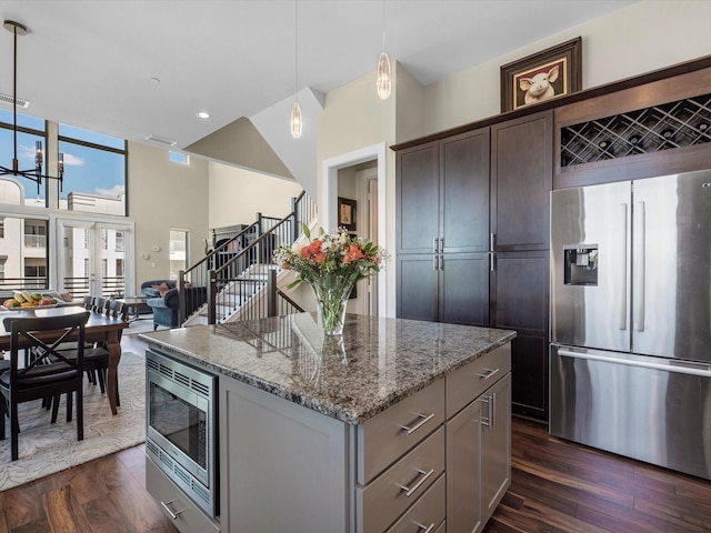 1437 Wagner St, Houston, TX 77007 - kitchen with appliances with stainless steel finishes, a center island, dark wood finished floors, light stone counters, and recessed lighting