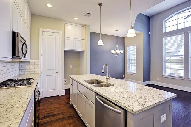 11005 Acorn Falls Dr, Houston, TX 77043 - kitchen with appliances with stainless steel finishes, dark wood finished floors, light stone countertops, a center island with sink, and recessed lighting