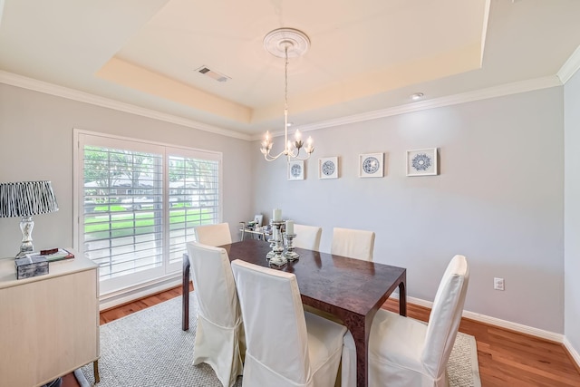 2018 Wakefield Dr, Houston, TX 77018 - dining room featuring a tray ceiling, light wood-style flooring, a chandelier, and ornamental molding