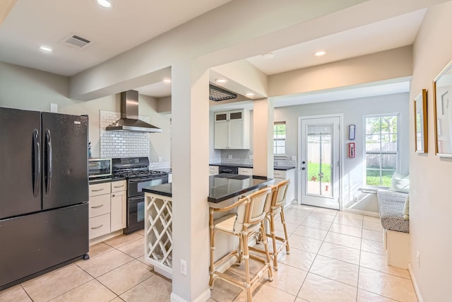 2018 Wakefield Dr, Houston, TX 77018 - kitchen with black appliances, wall chimney range hood, dark countertops, a breakfast bar, and recessed lighting