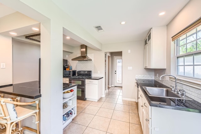 2018 Wakefield Dr, Houston, TX 77018 - kitchen with wall chimney range hood, gas stove, dark countertops, stainless steel microwave, and recessed lighting
