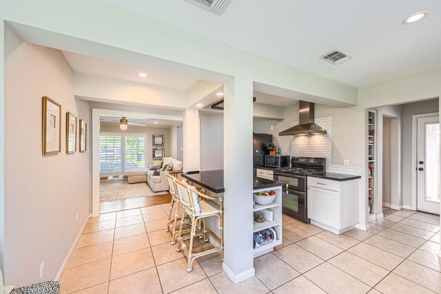 2018 Wakefield Dr, Houston, TX 77018 - kitchen with wall chimney exhaust hood, range with two ovens, dark countertops, open shelves, and stainless steel microwave