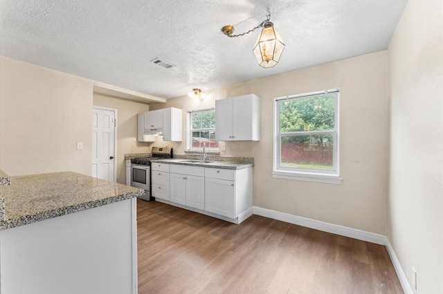 14106 Burtcliff St, Houston, TX 77060 - kitchen featuring stainless steel gas stove, light wood-style flooring, white cabinetry, a textured ceiling, and pendant lighting