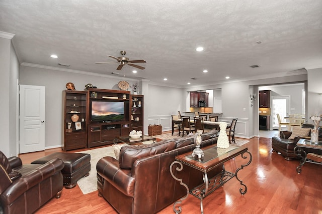 2640 Couch St, Houston, TX 77008 - living room with a ceiling fan, light wood-style flooring, ornamental molding, recessed lighting, and a textured ceiling