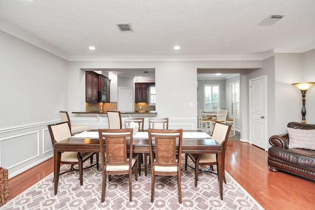 2640 Couch St, Houston, TX 77008 - dining room with wood finished floors, ornamental molding, a wainscoted wall, a decorative wall, and recessed lighting