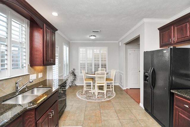 2640 Couch St, Houston, TX 77008 - kitchen featuring black appliances, reddish brown cabinets, dark stone counters, decorative backsplash, and ornamental molding